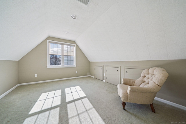 unfurnished room featuring light carpet and vaulted ceiling