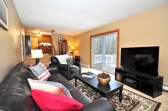 living room featuring light hardwood / wood-style floors and a baseboard heating unit