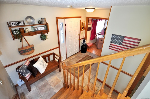 foyer entrance with a textured ceiling