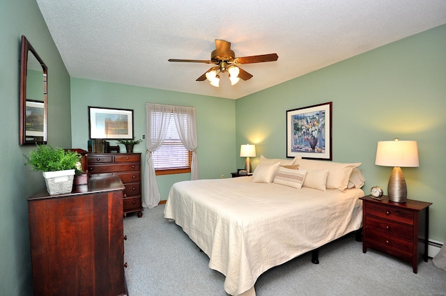 bedroom with light carpet, ceiling fan, a baseboard radiator, and a textured ceiling