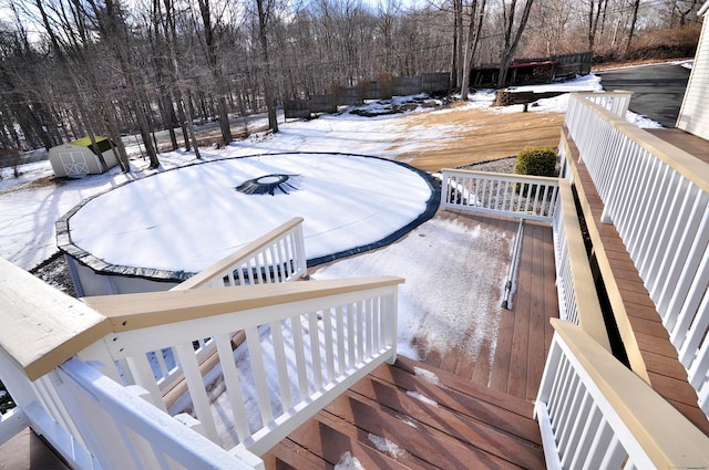 snow covered deck with a storage shed