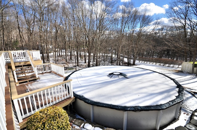 yard layered in snow with a pool side deck