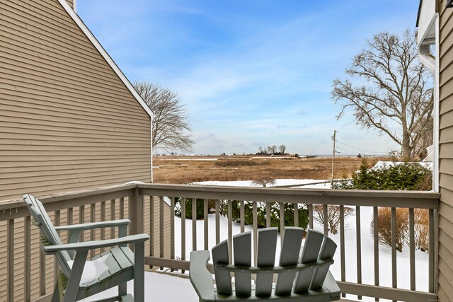 view of snow covered back of property