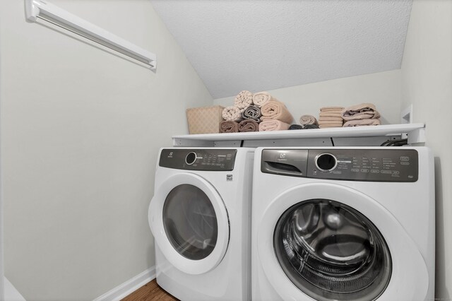 washroom featuring washer and dryer, hardwood / wood-style floors, and a textured ceiling