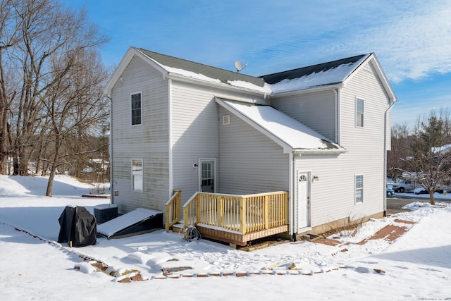 view of snow covered back of property