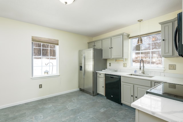 kitchen with gray cabinetry, sink, stainless steel appliances, and hanging light fixtures