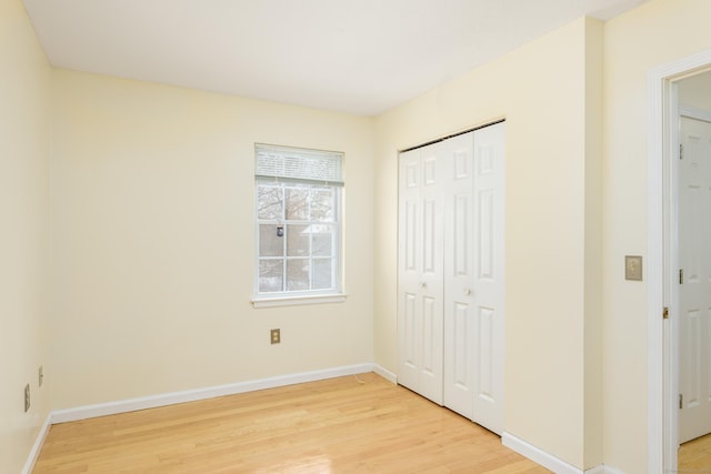 unfurnished bedroom with light hardwood / wood-style floors and a closet