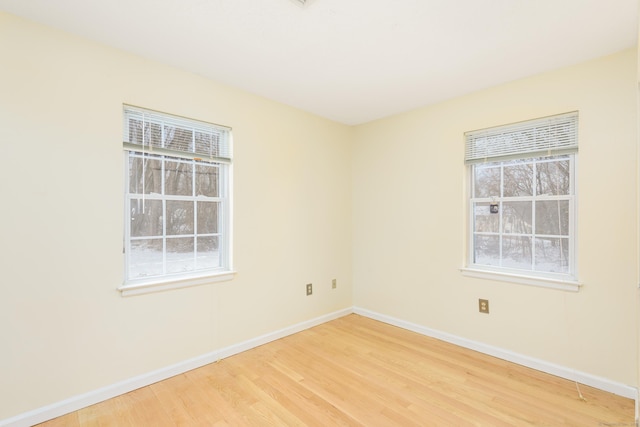 spare room featuring hardwood / wood-style flooring and plenty of natural light