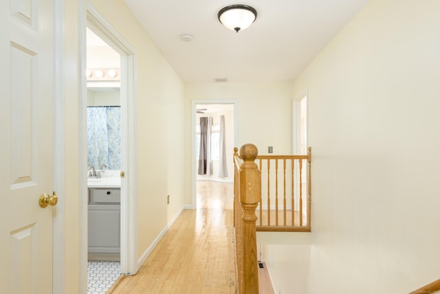 corridor featuring sink and light hardwood / wood-style flooring