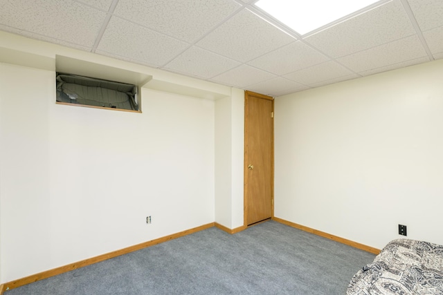 basement featuring a paneled ceiling and carpet floors