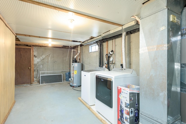 clothes washing area with washer and dryer and water heater