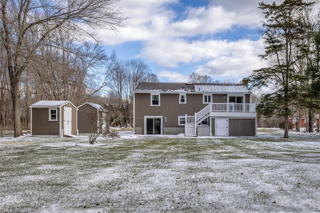 snow covered property featuring a wooden deck and a storage unit