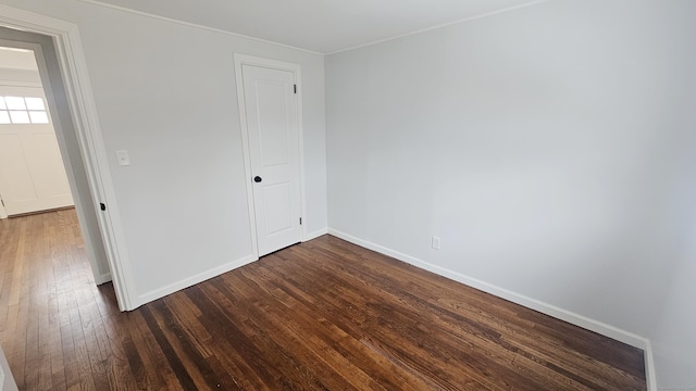 unfurnished bedroom with dark hardwood / wood-style flooring and a closet