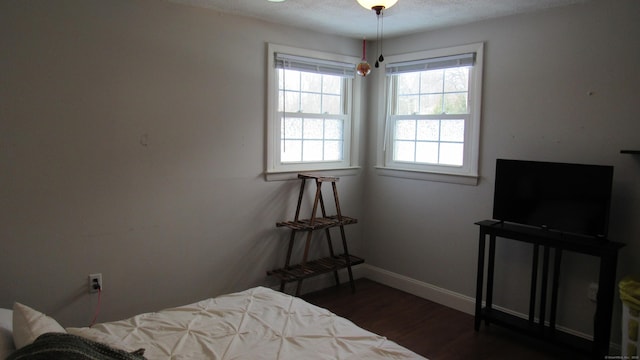 bedroom featuring dark hardwood / wood-style flooring and a textured ceiling