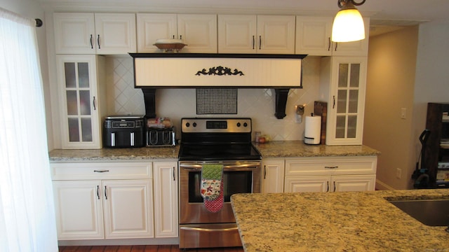 kitchen with stainless steel range with electric stovetop, hanging light fixtures, light stone countertops, and white cabinets