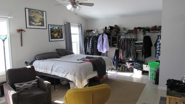 tiled bedroom with ceiling fan and lofted ceiling