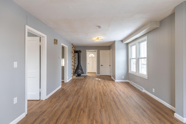 interior space with dark wood-type flooring and a wood stove