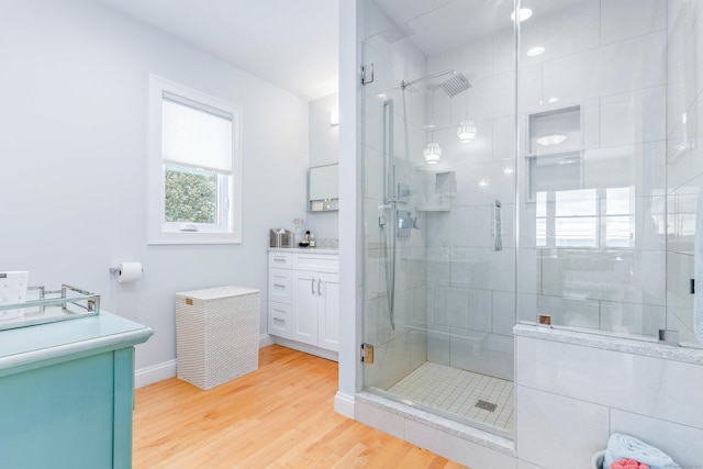 bathroom featuring a shower with door, vanity, and hardwood / wood-style floors