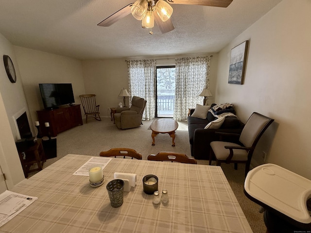 carpeted dining space featuring ceiling fan and a textured ceiling