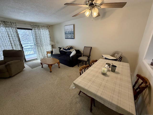 carpeted dining space featuring ceiling fan and a textured ceiling