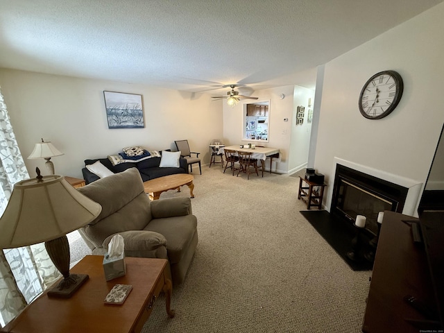 carpeted living room with ceiling fan and a textured ceiling