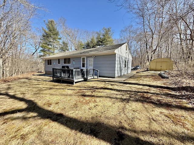 back of property with a storage unit, an outdoor structure, and a deck