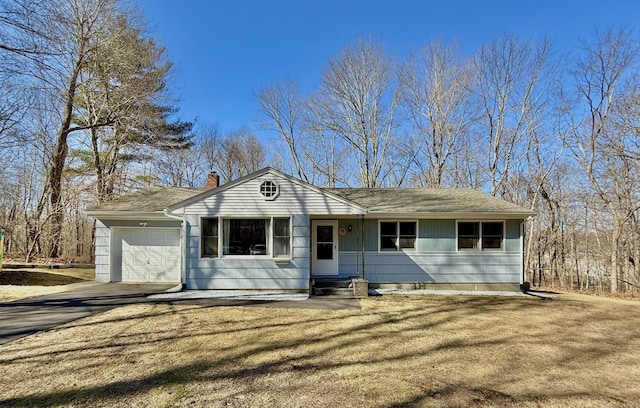 ranch-style home featuring aphalt driveway, a front lawn, a chimney, and an attached garage