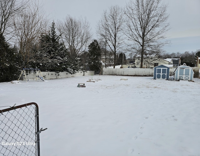 yard layered in snow with a playground