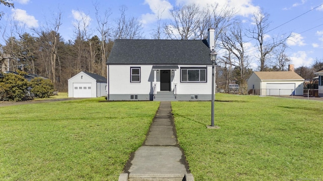 bungalow-style home featuring a garage, an outdoor structure, and a front yard