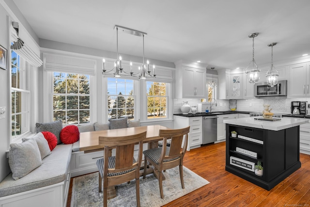 kitchen featuring appliances with stainless steel finishes, dark countertops, a kitchen island, and pendant lighting