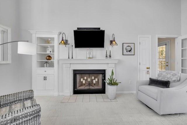 living room with a fireplace with flush hearth and baseboards