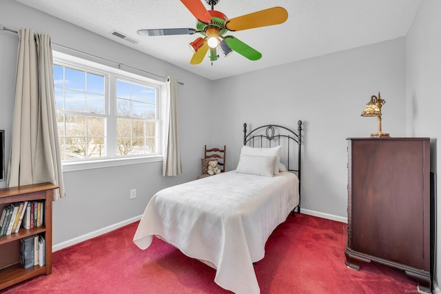 carpeted bedroom featuring a ceiling fan, visible vents, and baseboards