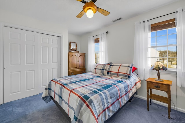 bedroom with baseboards, visible vents, dark carpet, and a closet