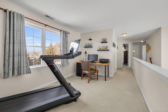 exercise area with baseboards, visible vents, and light colored carpet