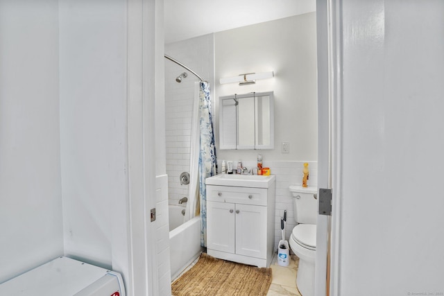 full bathroom featuring shower / bath combo with shower curtain, tile walls, vanity, tile patterned flooring, and toilet