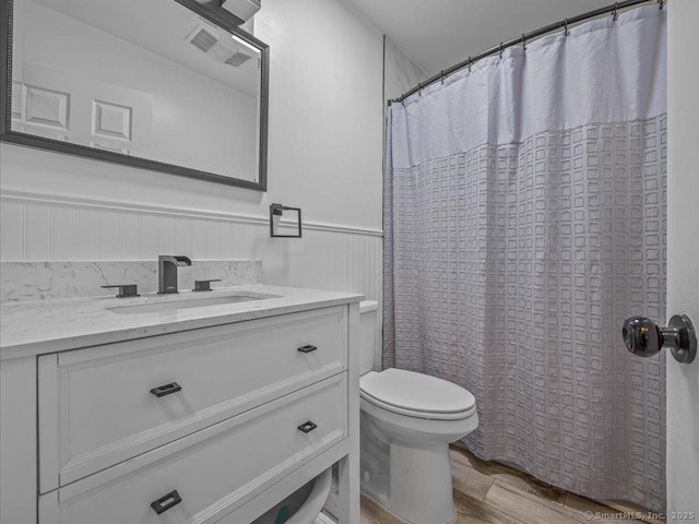 bathroom featuring vanity, hardwood / wood-style floors, a shower with shower curtain, and toilet