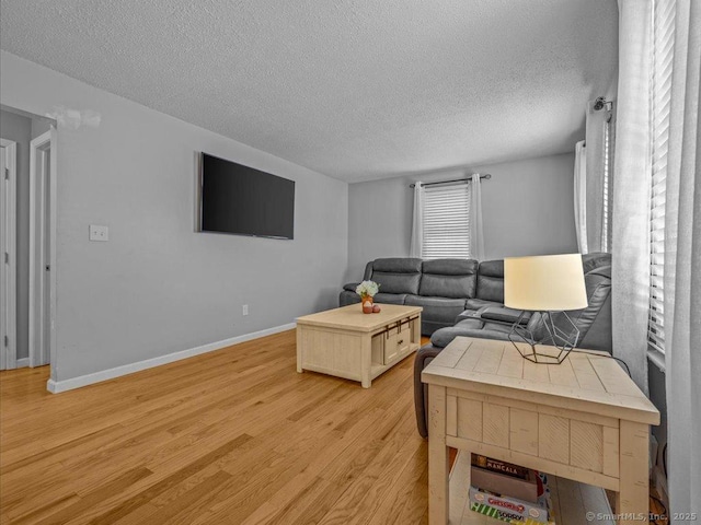 living room with light hardwood / wood-style floors and a textured ceiling