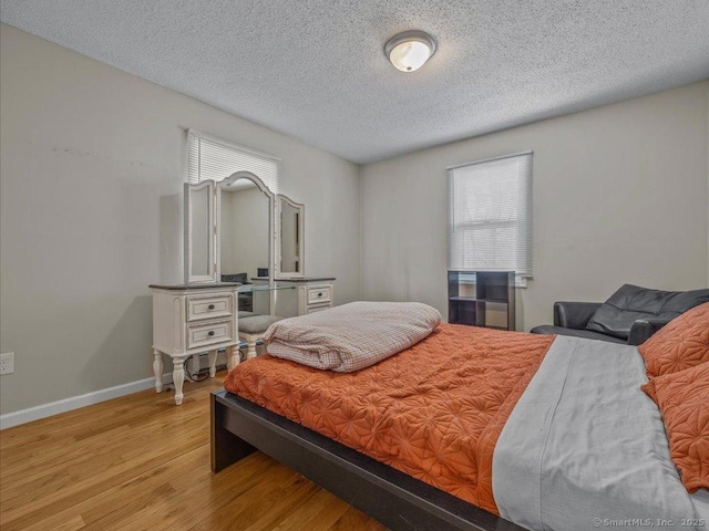 bedroom featuring a textured ceiling and light wood-type flooring