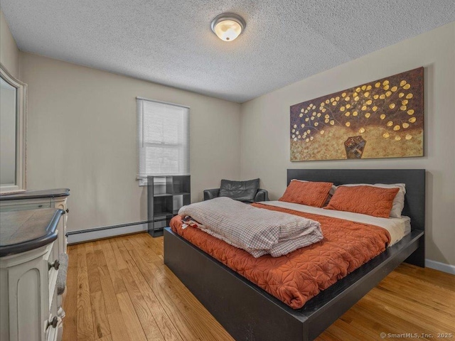 bedroom featuring a baseboard radiator, a textured ceiling, and light wood-type flooring