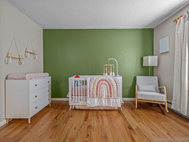 unfurnished bedroom with a textured ceiling and light wood-type flooring