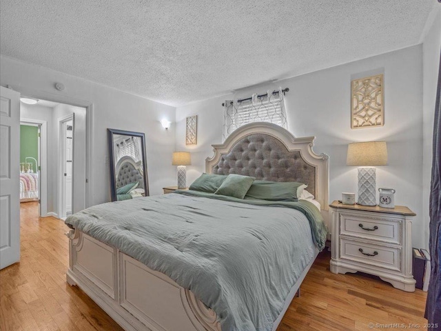 bedroom featuring light hardwood / wood-style flooring and a textured ceiling