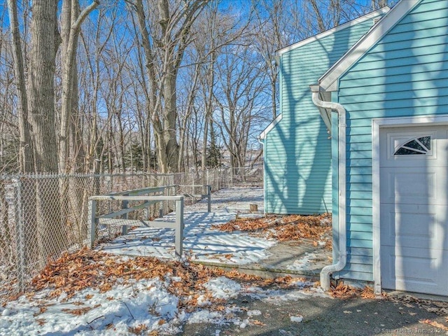 yard layered in snow featuring a garage