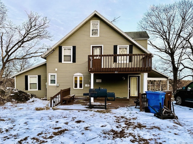 snow covered house featuring a balcony