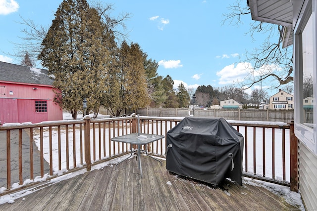 snow covered deck with a grill