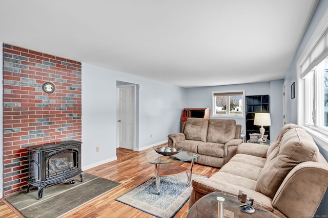 living room with light hardwood / wood-style floors and a wood stove