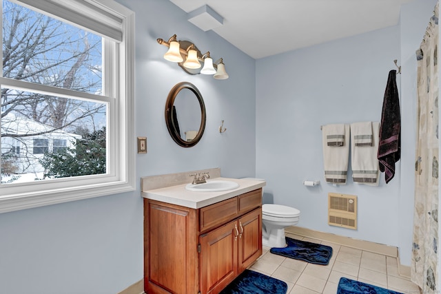 bathroom with vanity, a healthy amount of sunlight, heating unit, and tile patterned floors