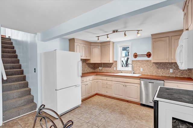 kitchen featuring sink, white appliances, light tile patterned floors, tasteful backsplash, and light brown cabinets