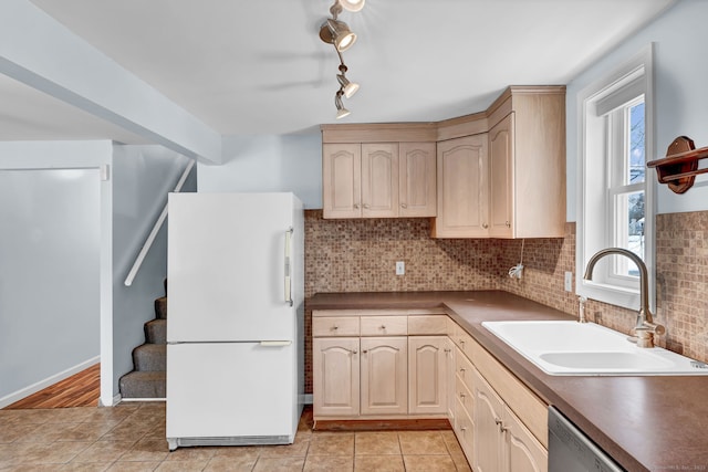 kitchen with sink, light brown cabinets, dishwasher, white fridge, and backsplash