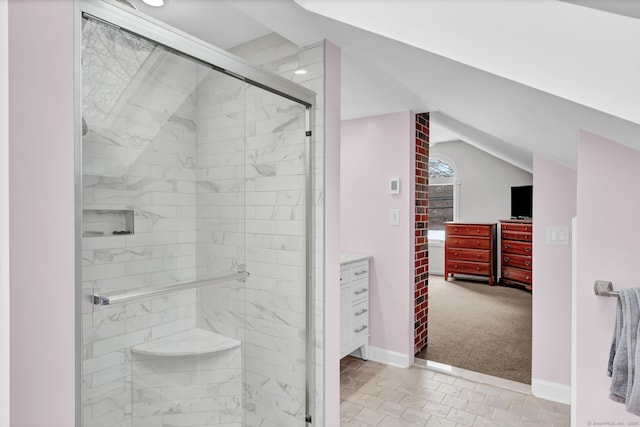 bathroom featuring walk in shower, vanity, and vaulted ceiling