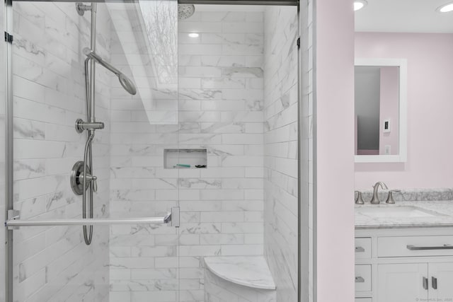 bathroom with vanity and a shower with door